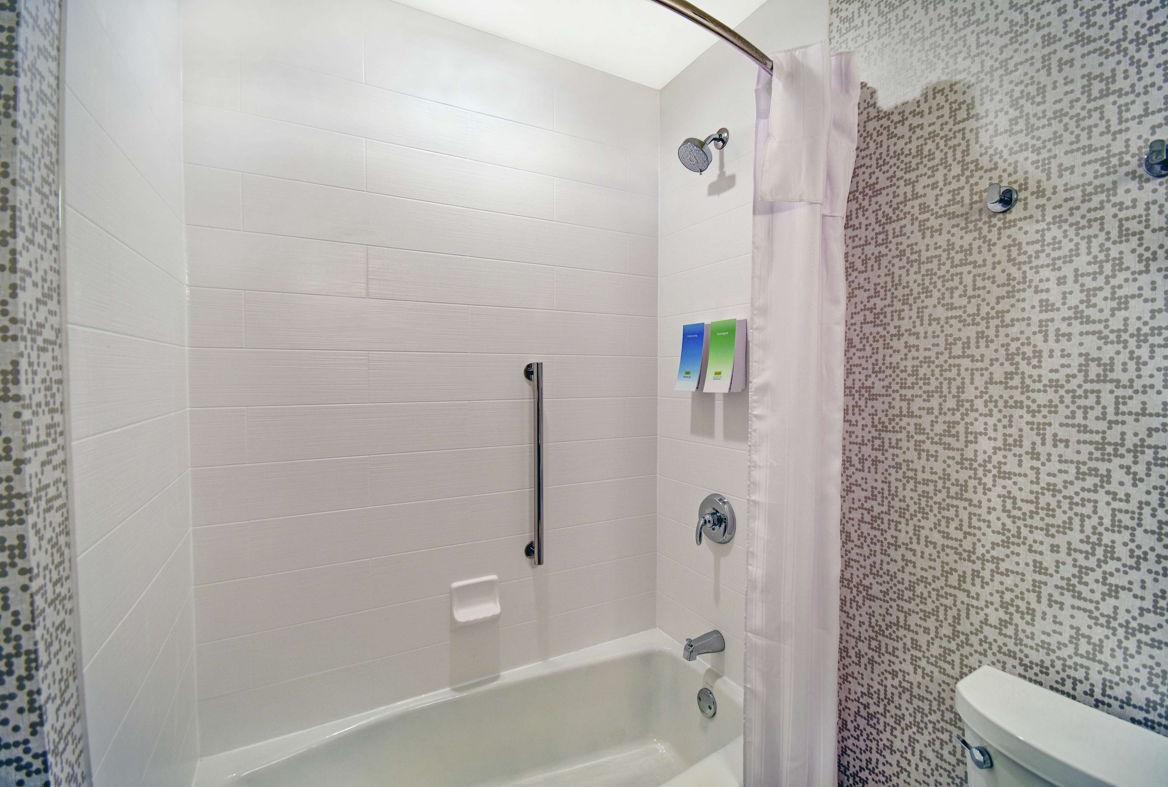 A bathroom with a shower, toilet, and a bathtub.
