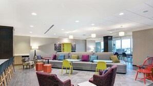 Een moderne zithoek met een bank, stoelen, tafels en een koffiehoek.