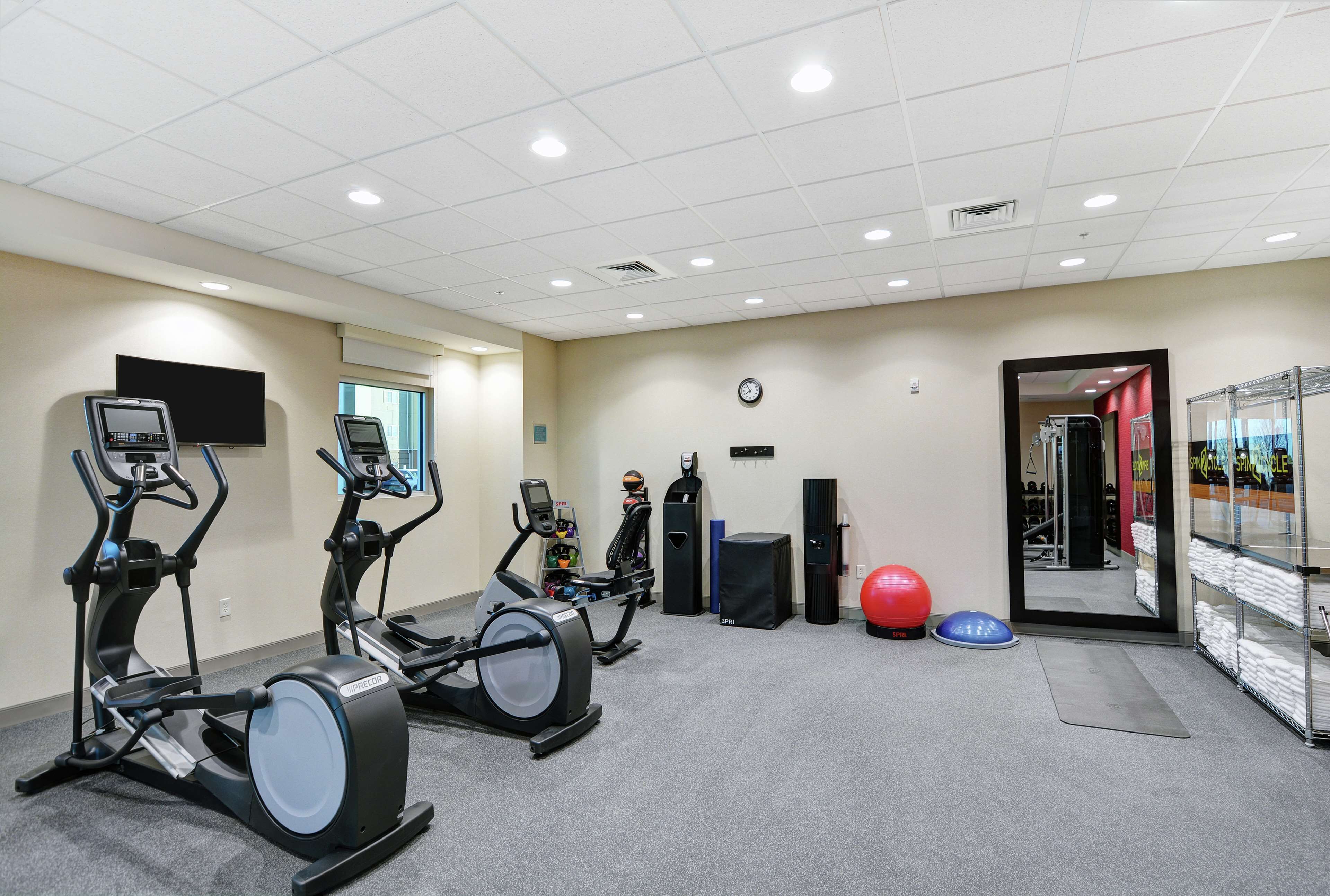 A gym with stationary bikes, a treadmill, and exercise balls.