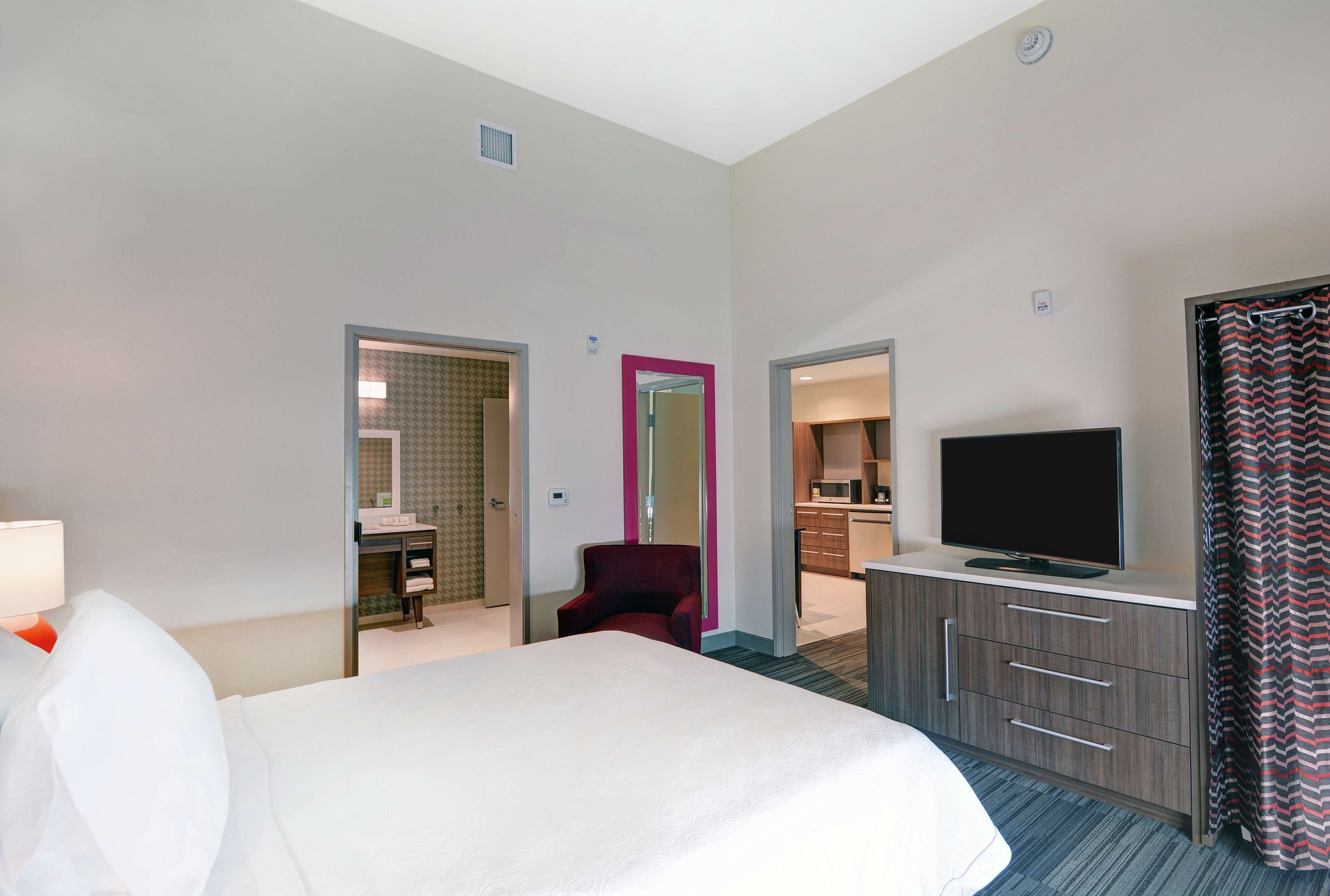 Una habitación de hotel con cama, televisión, escritorio y una silla.