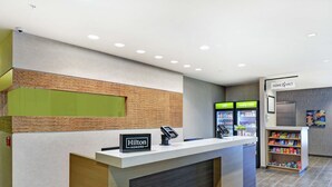 Een hotel receptie met een modern design, inclusief een balie met een bord waarop 