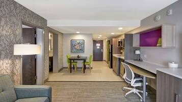 Une chambre d’hôtel moderne équipée d’un coin repas, d’un bureau et d’une chaise.