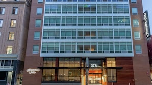 A modern hotel with a brick facade, large windows, and a prominent entrance. - Hampton Inn Oakland Downtown-City Center (Oakland)