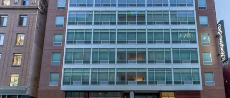 A modern hotel with a brick facade, large windows, and a prominent entrance.
