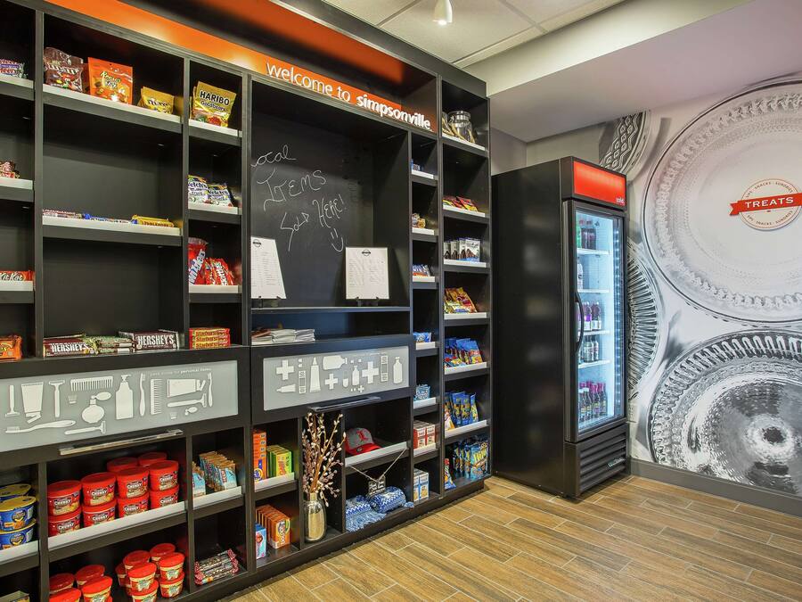 Een vitrine met verschillende pakjes snacks en een schoolbord.