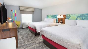 A hotel room with two beds, a desk, a chair, a TV, and a window with a view.