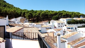 A coastal town with white buildings, terracotta roofs, and a backdrop of green hills. - IDEAL RURAL HOUSING TO ENJOY PEACE AND TRANQUILITY (EL GASTOR)