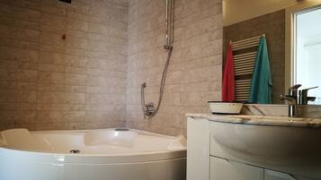 A bathroom with a bathtub, a shower, and a sink.