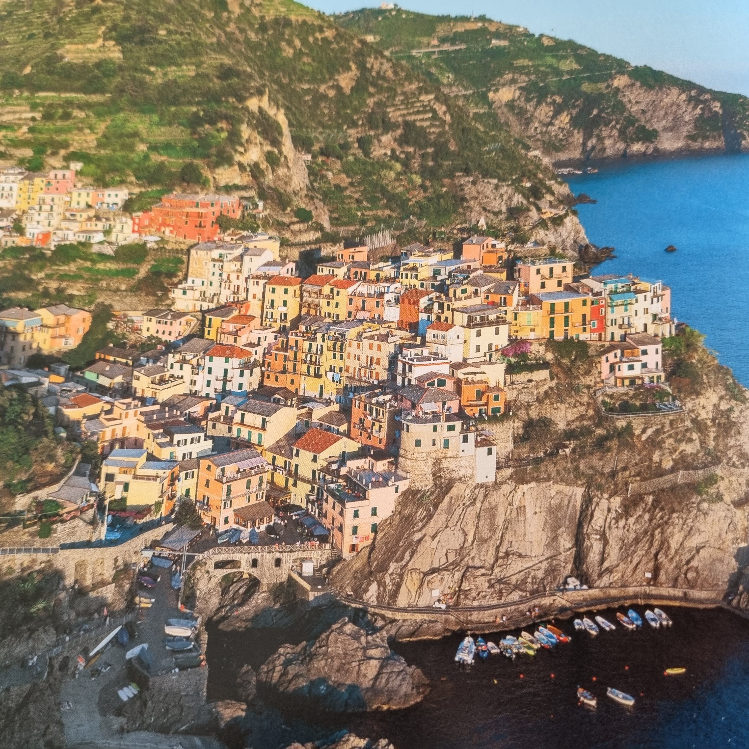 A coastal town with colorful buildings clustered along a cliffside, overlooking the sea.