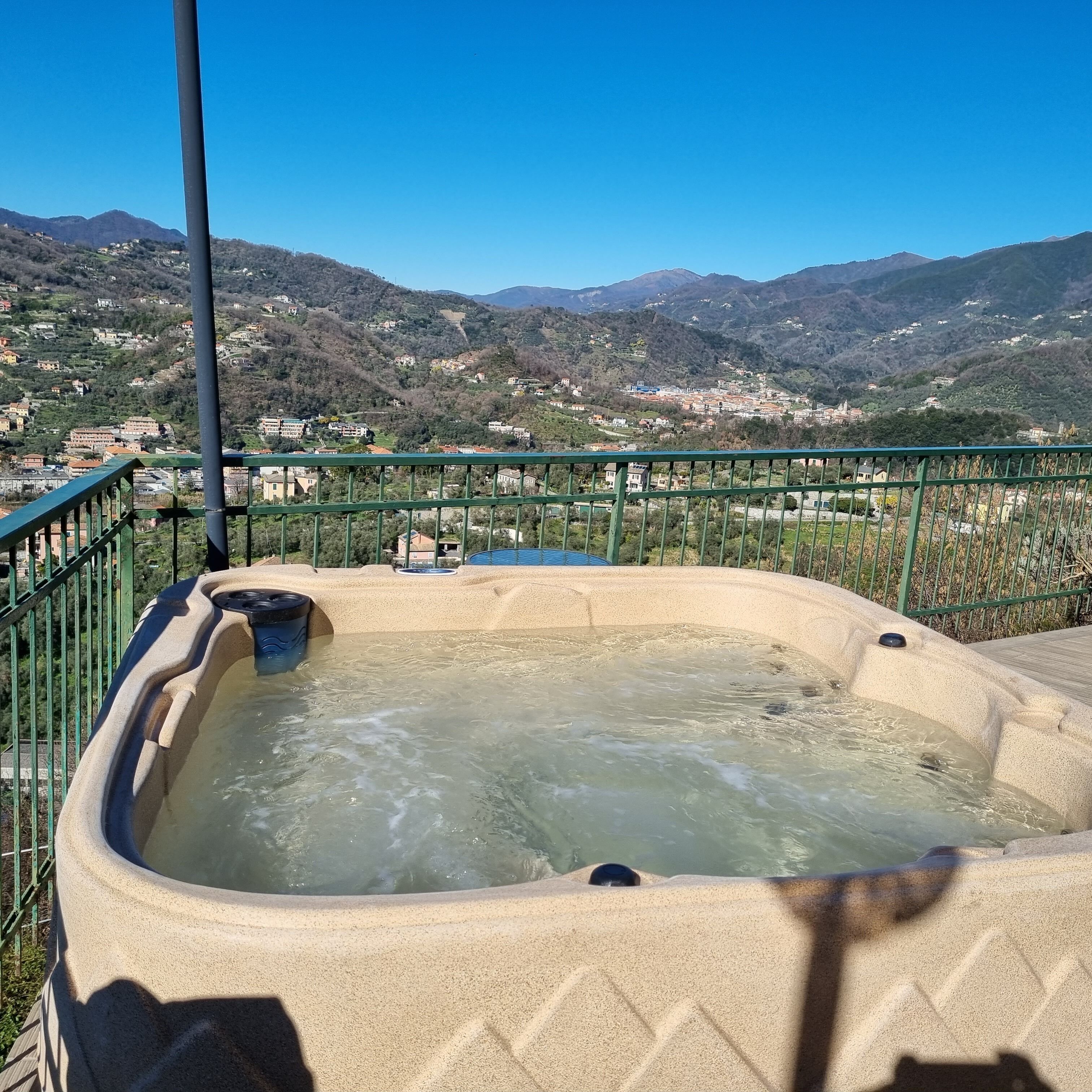 A hot tub with a view of a mountainous landscape.