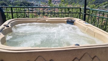 Ein Whirlpool mit Blick auf eine Küstenstadt und Hügel.