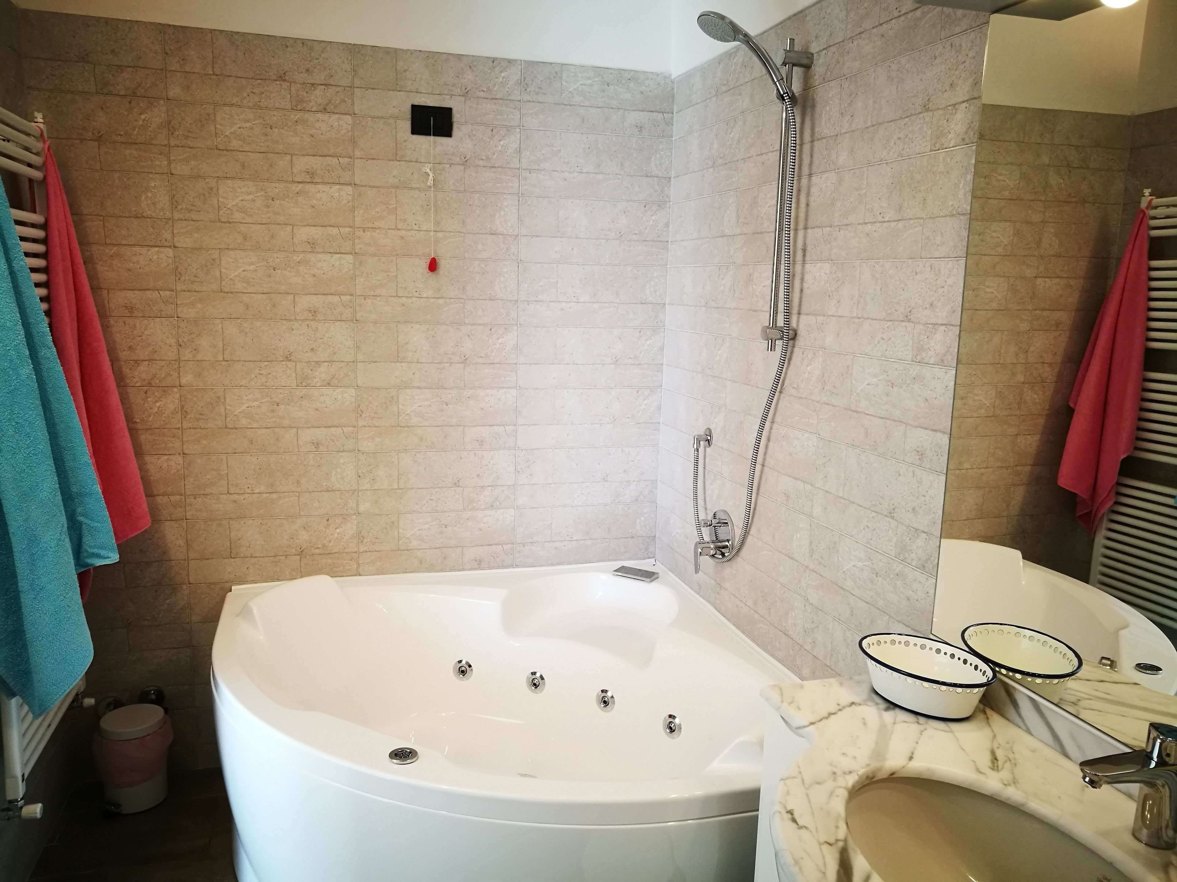 A bathroom with a bathtub, a shower, a toilet, and a sink with a mirror.