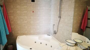 A bathroom with a bathtub, a shower, a toilet, and a sink with a mirror.
