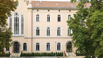 A multi-story building with arched windows and a symmetrical facade.