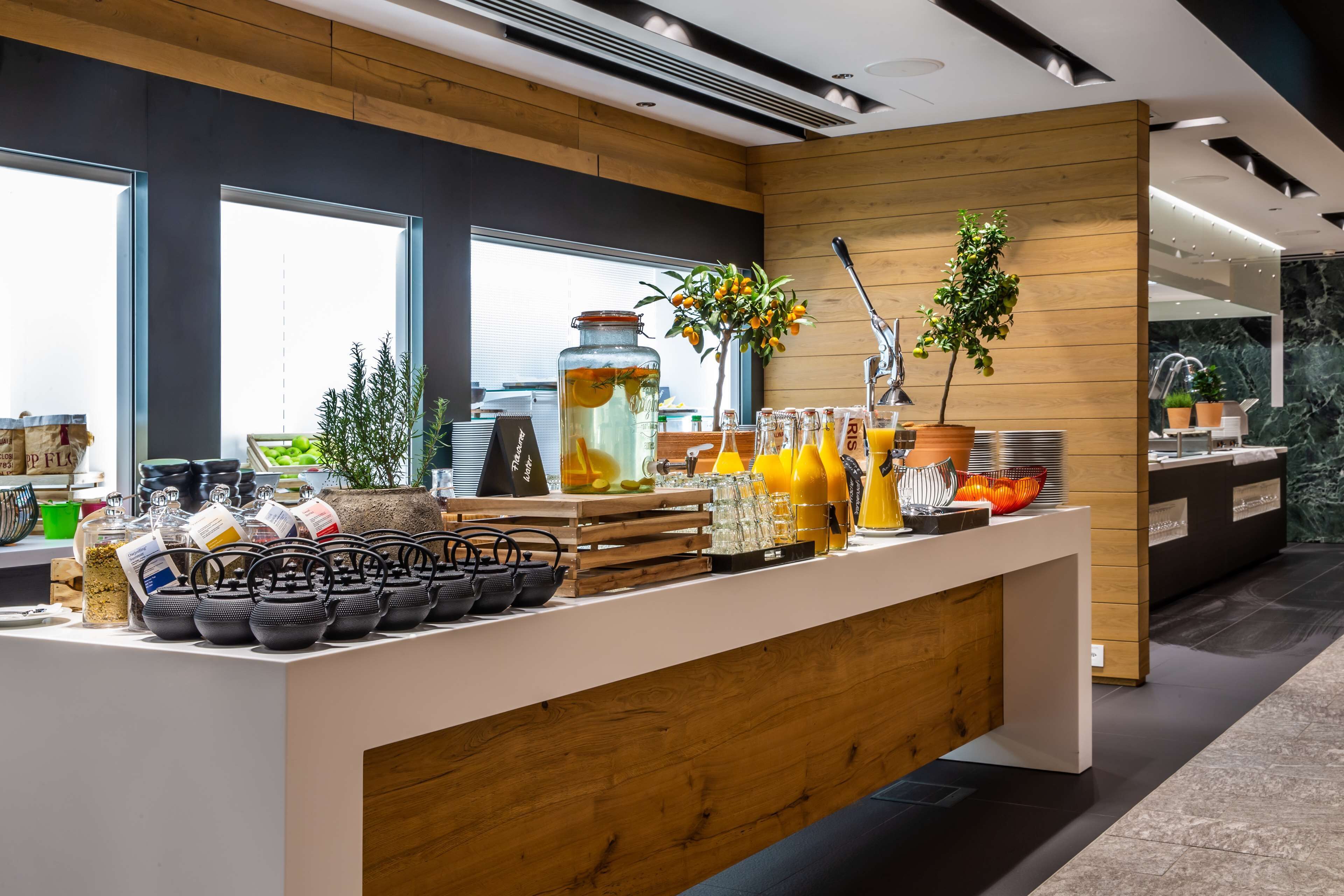 Una barra de desayuno moderna con mostrador de madera, ventanas amplias y diferentes opciones para el desayuno.
