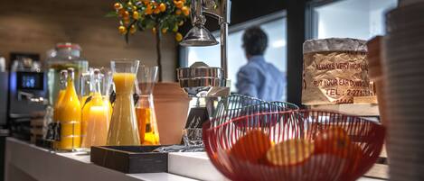 A bar area with various beverages, a metal bowl, and a decorative plant.
