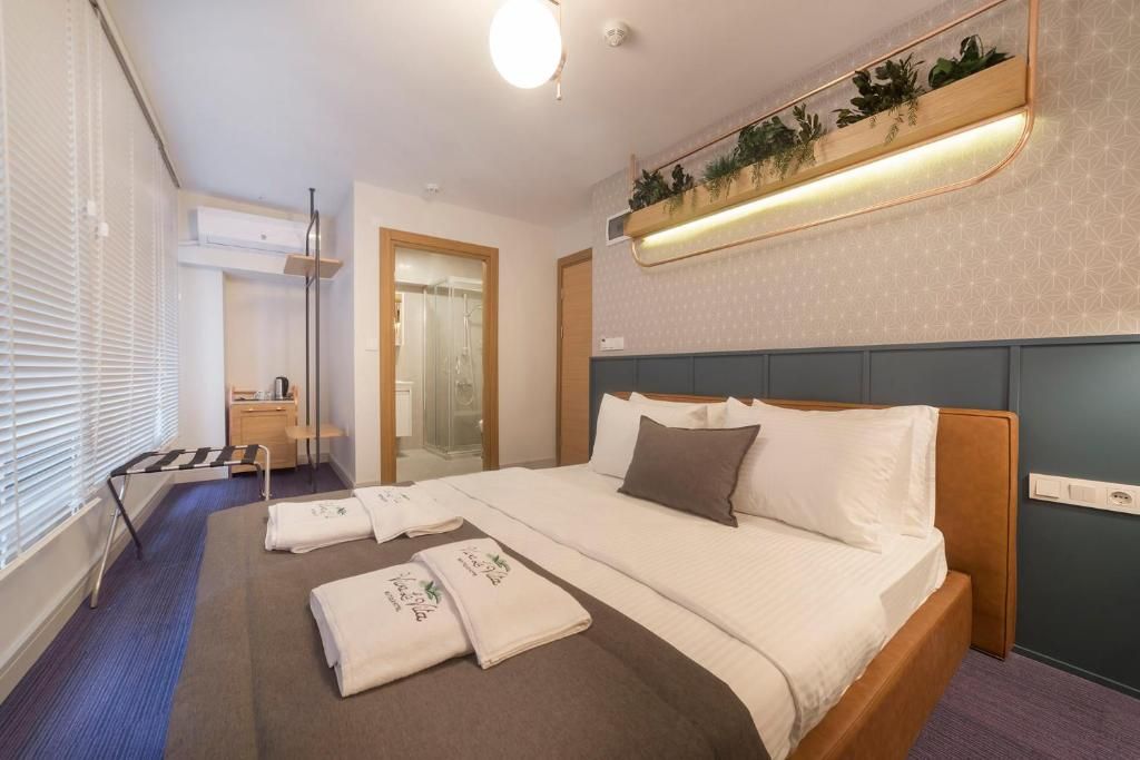 A hotel room with a bed, bedside table, and a small desk.