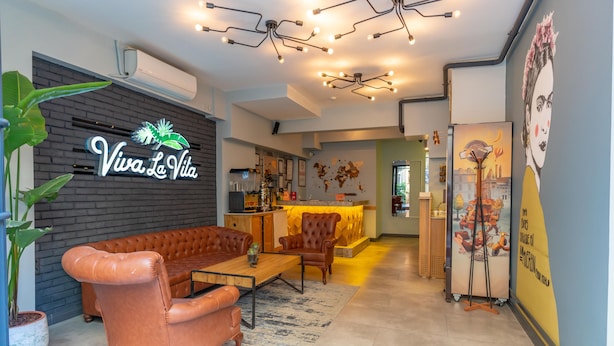A modern interior with a leather sofa, a bar area, and a world map on the wall.