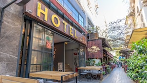 A hotel with outdoor seating and a visible entrance.