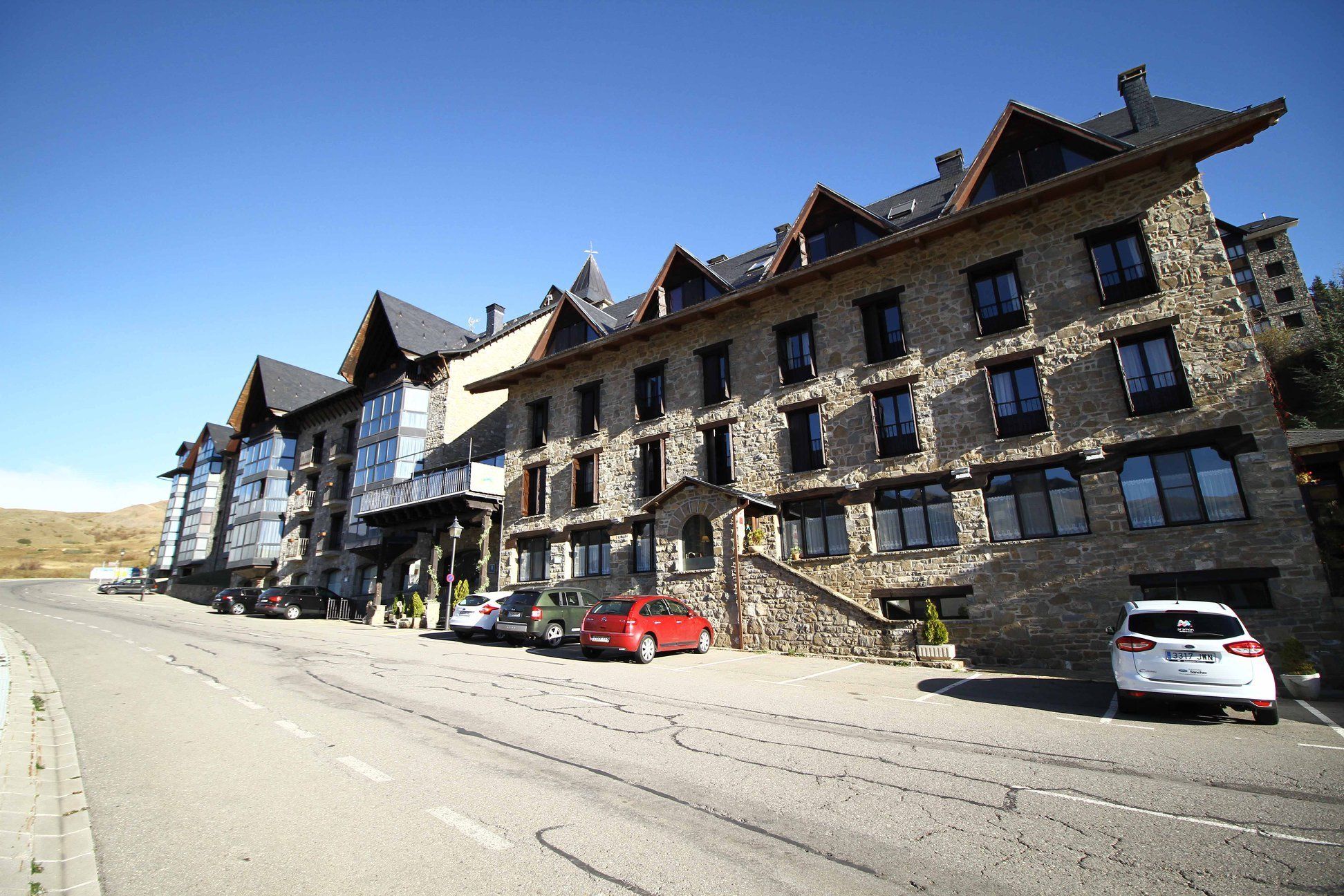Un edificio de varios pisos de piedra, con un estilo arquitectónico tradicional, que cuenta con múltiples ventanas y balcones.