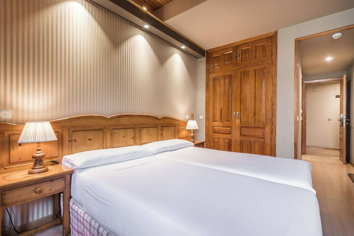 Cortinas blackout, tabla de planchar con plancha y ropa de cama