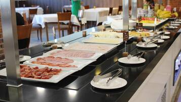 Ein Buffet mit verschiedenen Speisen, darunter Fleisch- und Käseauswahl, in einem Restaurant.