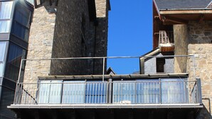 A stone building with a balcony, a large entrance door, and a sign indicating handicap accessibility. - YoY Villa de Sallent 4 (Sallent de Gallego)
