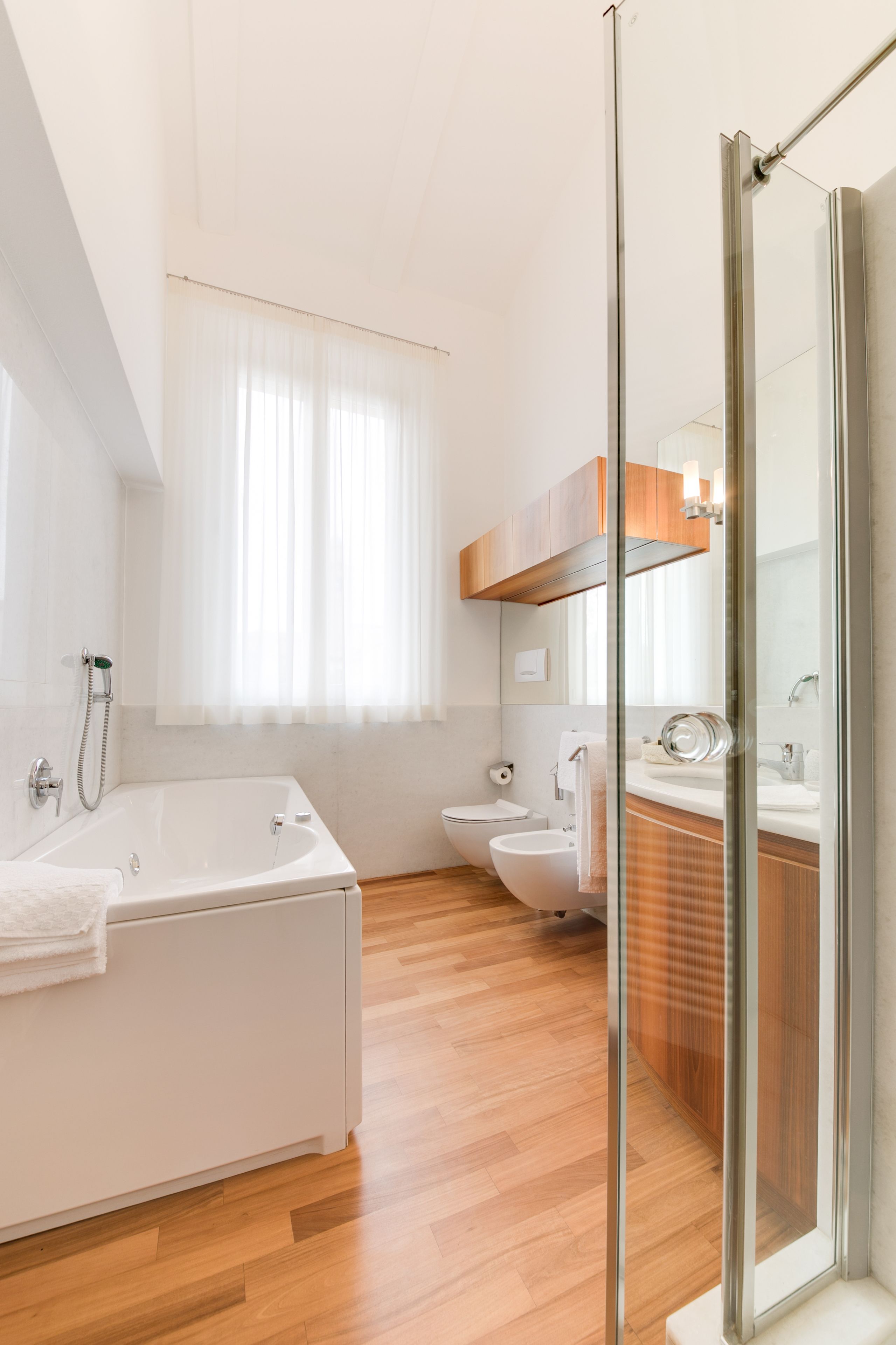 A modern bathroom with a bathtub, toilet, and shower area.