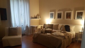A hotel room with a bed, a chair, a desk, and a window with curtains. - Appartamento Gradisca (Lecco)