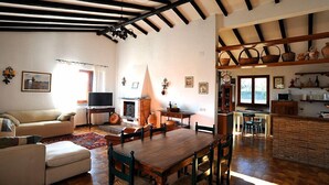 Amplia sala de estar con una mesa de comedor de madera, un sofá y una chimenea.