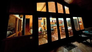 A room with a large window overlooking a dining area. - 2 Bedroom Hand Crafted Luxury Home with Jacuzzi & Fireplace (Volcano)