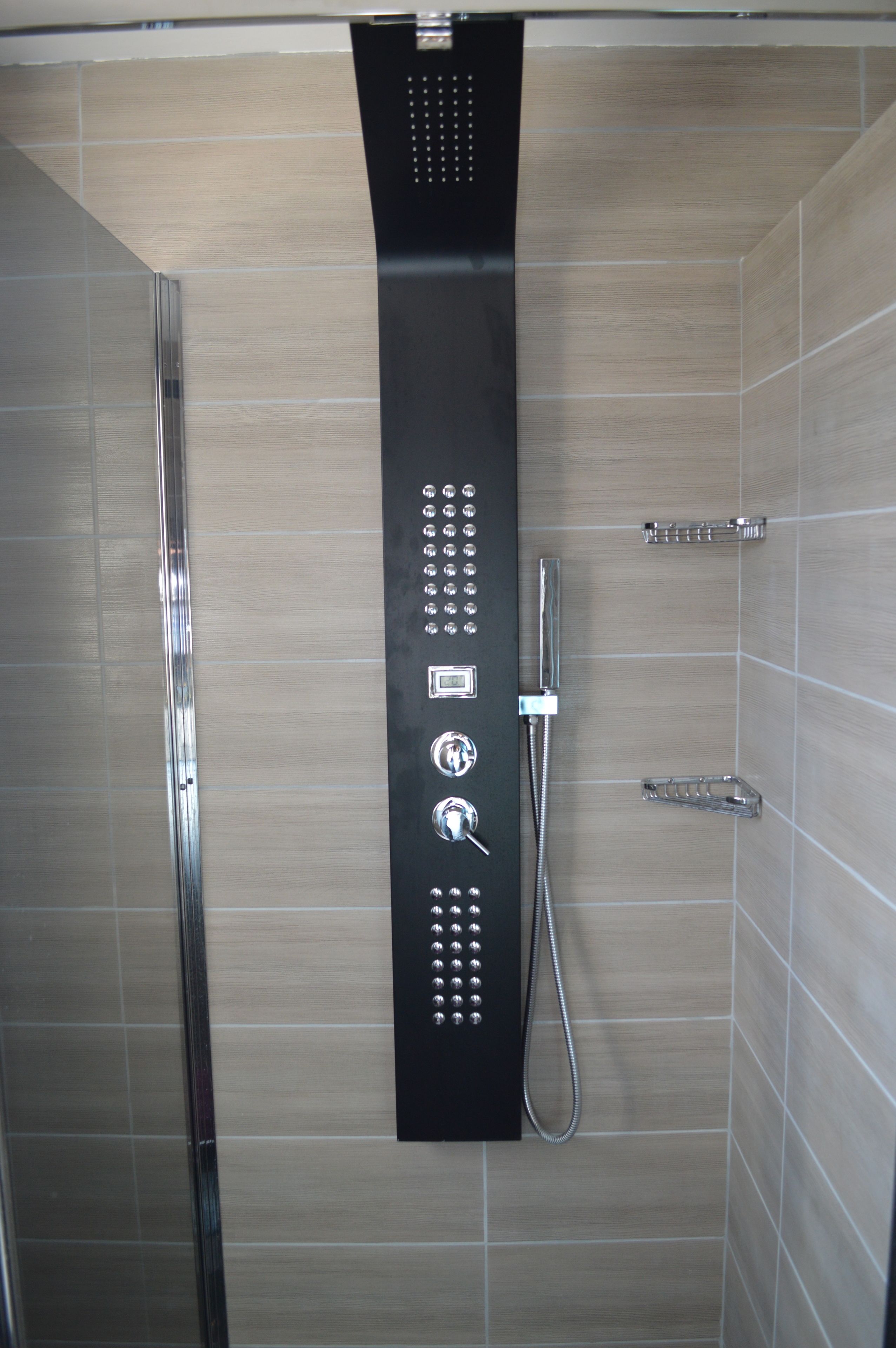 Um chuveiro moderno com painel de controle, chuveiro manual e torneira embutida.