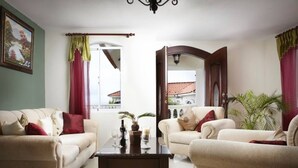 Una sala de estar con dos sofás color beige, una mesa de centro y un espejo grande.