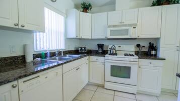 Condo Confort | Cocina privada | Refrigerador, cafetera y tetera y comedor