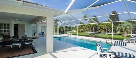 Una piscina al aire libre, sillones reclinables de piscina