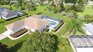 Zona residencial con casas, piscina y abundante vegetación.