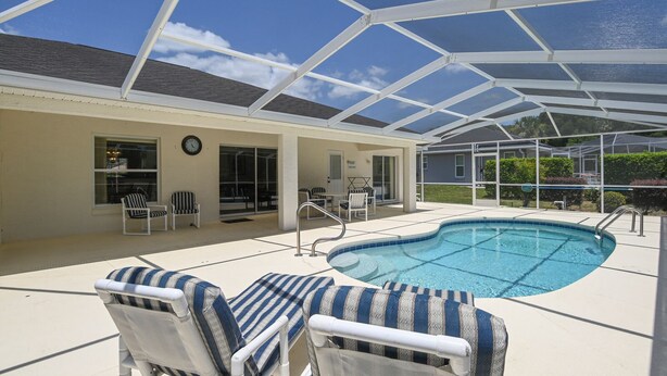 A covered outdoor swimming pool with lounge chairs and a patio area. - Villa Grandjean - Comfort - 4 Bedroom (Inverness)