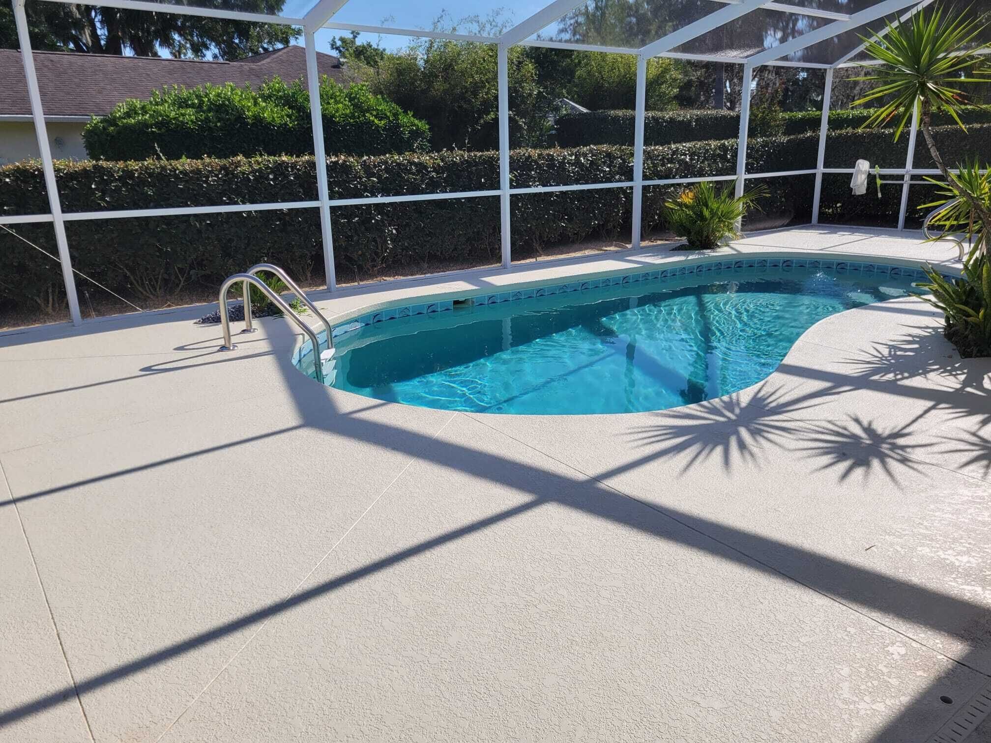 Una piscina con un solarium bianco e una struttura in vetro.