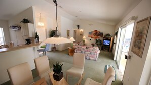 Una sala de estar con sofá, sillas, una mesa de centro y televisor.