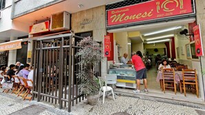 Un restaurant anomenat 'Monesi' amb terrassa i un quadre de preus a la vista.