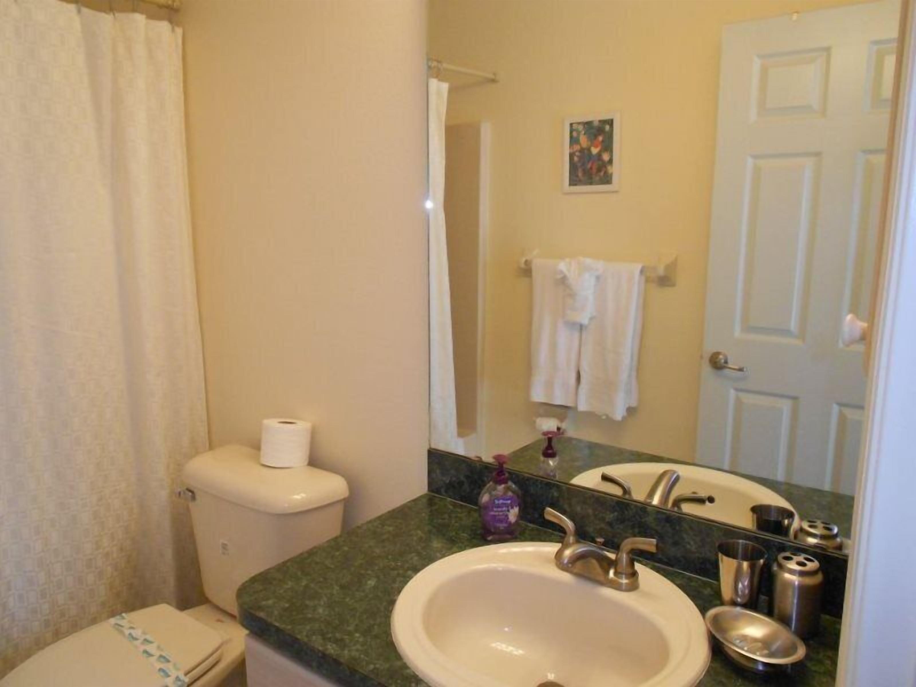 Un baño con inodoro, lavamanos y ducha.