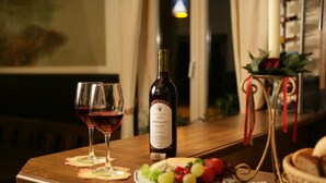 A table with a bottle of wine, two glasses, a plate of food, and a candle holder. - Nassauer Hof Hotel & Weinwirtschaft (Sankt Goarshausen)