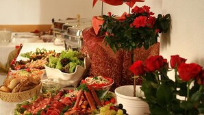 A buffet table with various food items and a decorative plant. - Nassauer Hof Hotel & Weinwirtschaft (Sankt Goarshausen)