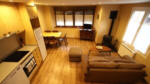 Un espacio habitable compacto con kitchenette, comedor y zona de estar.