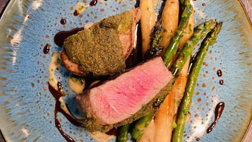 A plate of food with steak, asparagus, and potatoes.