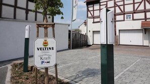 A building with a sign for 'Veltins Gasthof Kraft' and a parking sign. - Gasthaus Kraft (Schauenburg)