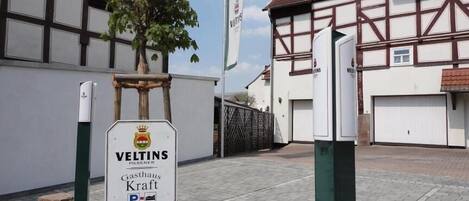 Un bâtiment avec une enseigne indiquant « Veltins Gasthof Kraft » et un panneau de signalisation pour indiquer un parking.