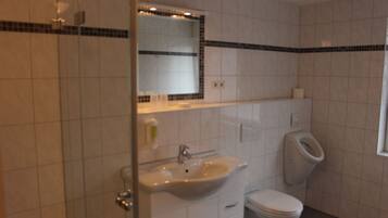 Un baño con lavamanos blanco, inodoro y espejo.