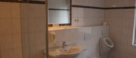 Un baño con lavamanos blanco, inodoro y espejo.