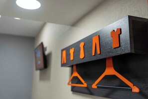 A wall with a wooden panel and orange hangers. - easyHotel Ipswich (Ipswich)